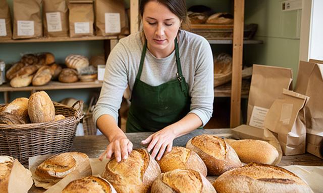 Maltby bakery owner arranging fresh loaves in a small shop for wholesale customers